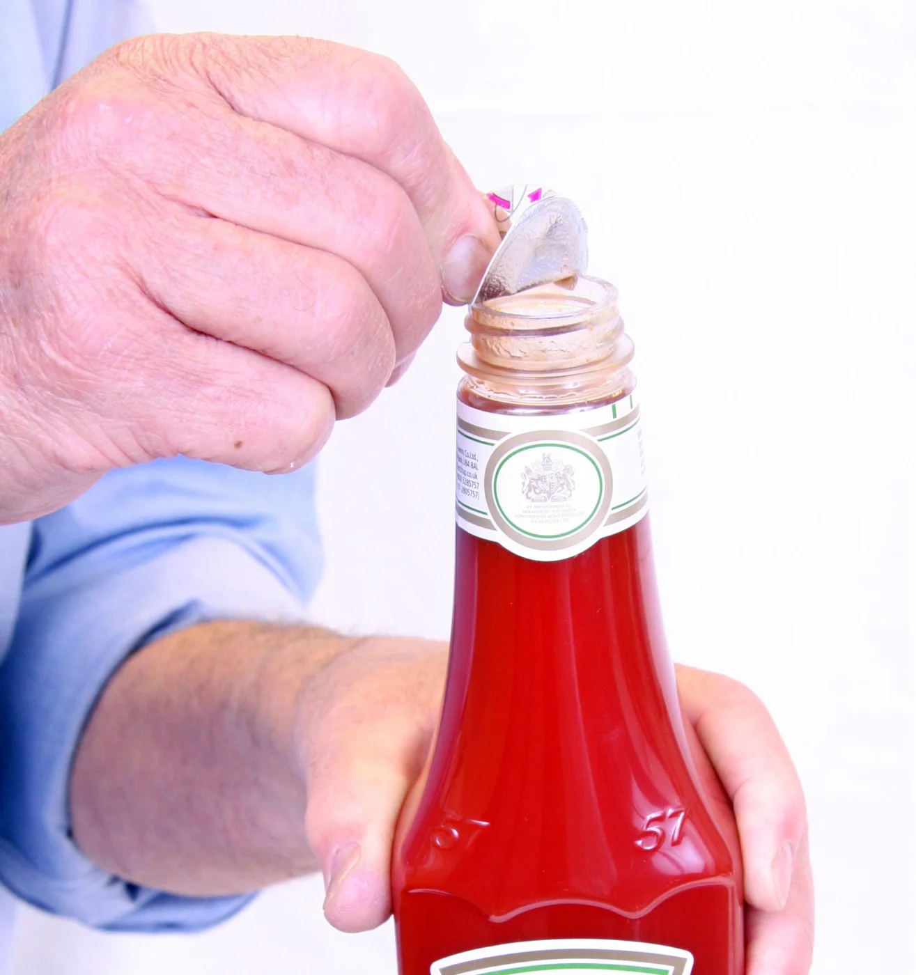 Hand peeling the induction seal off a container